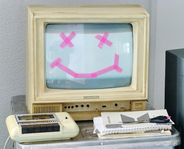 an old computer with smiley face